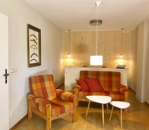 ein Wohnzimmer mit 2 Stühlen und einem Tisch in der Unterkunft Ferienwohnung Ursel in Heringsdorf