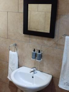a bathroom with a white sink and a mirror at Ditsaleng Bed and Breakfast in Vanderbijlpark