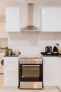 a kitchen with a stove and white cabinets at Villa Number 4 in Sharjah