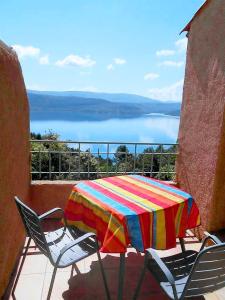 a colorful table and chairs on a balcony with a view at Appartement d'une chambre avec vue sur le lac terrasse amenagee et wifi a Sainte Croix du Verdon a 2 km de la plage in Sainte-Croix-de-Verdon