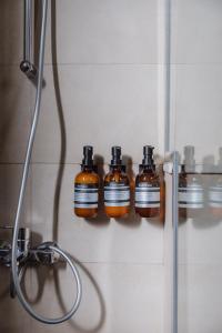 4 bouteilles de savon sur un mur dans une salle de bains dans l'établissement Villa Number 4, à Charjah