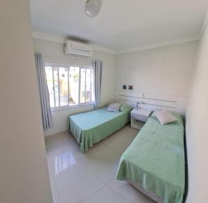 a hospital room with two beds and a window at Apartamentos Vida Mansa in Bombinhas +25 photos