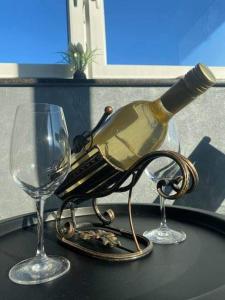 una botella de vino sentada en una mesa con dos copas en Apartma Lara, en Lesično