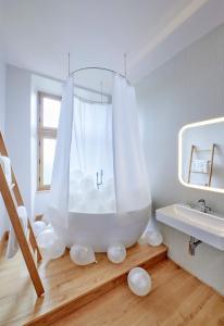a bathroom with a white tub and a sink at Dépendance de Sibra in Lagarde +11 photos