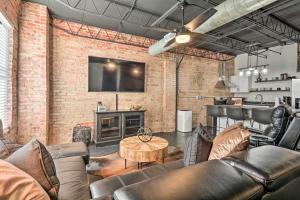 a living room with leather furniture and a tv at Sleek, Modern Loft in Downtown Springfield! in Springfield
