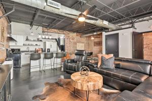 a living room with a leather couch and a table at Sleek, Modern Loft in Downtown Springfield! in Springfield