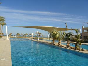 a swimming pool with a canopy over it with palm trees at Mangroovy - 1BR Glamorous Gouna view condo in Hurghada