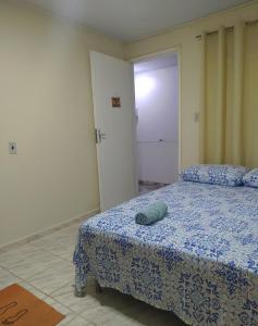 a bedroom with a bed with a blue comforter at Hostel Unamar in Cabo Frio