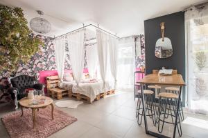 - une chambre avec un lit, une table et des chaises dans l'établissement Romantisme et glamour 2 avec spa , clim et jardin, à Dijon
