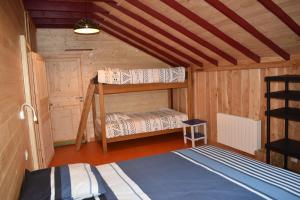a room with two bunk beds in a cabin at Gîte de Montagne "Les Ecorces" in La Bresse