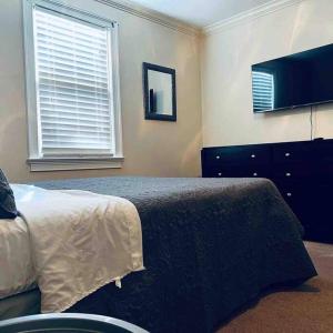 a bedroom with a bed and a dresser and a television at Southern Comfort in Albany