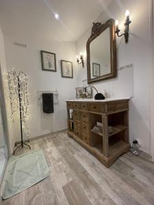 een badkamer met een wastafel en een spiegel aan de muur bij L'Amandari in Plan-de-la-Tour