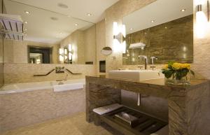 
a bathroom with a sink, mirror, and bathtub at Radisson Blu Royal Hotel Dublin in Dublin
