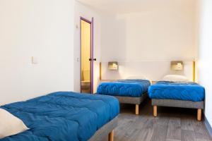 サランにあるMister Bed Saranの青い毛布が備わる客室内のベッド2台