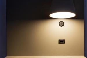 une lumière sur un mur avec une horloge. dans l'établissement Mister Bed Saran, à Saran