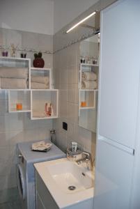 uma casa de banho com um lavatório e uma máquina de lavar roupa em Il porticciolo em Bellano