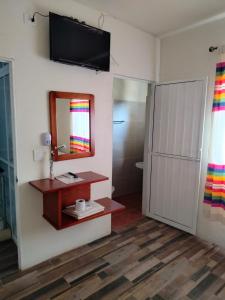 baño con espejo y TV en la pared en Casa shambieda en Santa Cruz - Huatulco