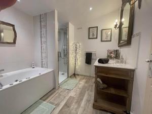 een badkamer met een bad, een wastafel en een douche bij L'Amandari in Plan-de-la-Tour