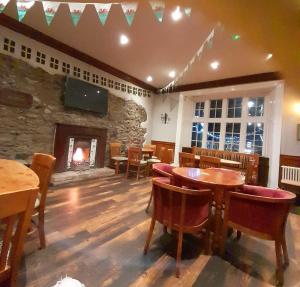 a restaurant with tables and chairs and a fireplace at The Bull Hotel in Llangefni