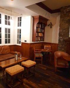 ein Wohnzimmer mit einem Sofa, einem Tisch und Stühlen in der Unterkunft The Bull Hotel in Llangefni