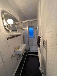 uma pequena casa de banho com um lavatório e um espelho em Adam's Hostel - Self Check-In & Room Just For You Alone em Düsseldorf