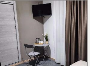 里米尼的住宿－Hotel Crisvan，一张带两把椅子的小桌子和墙上的一台电视