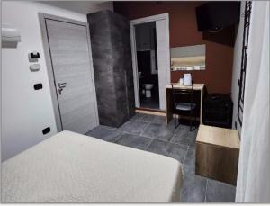 een slaapkamer met een bed en een bureau en een badkamer bij Hotel Crisvan in Rimini
