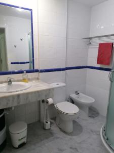 a bathroom with a sink and a toilet and a mirror at Casa Maya in Corralejo