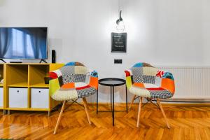 2 sedie e un tavolo in una camera con TV di Rex Nest a Cluj-Napoca
