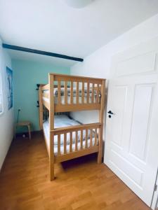 two bunk beds in a room with a door at Ferienhäuschen im Grünen in Weimar