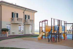 un parque infantil con un tobogán frente a un edificio en Sea view apartment en San Vincenzo
