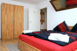 a bedroom with a red and blue bed with a wooden cabinet at Aparthotel Kompass A 102-103 in Essen