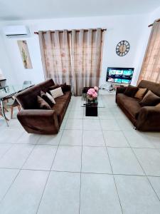 uma sala de estar com dois sofás e uma televisão em Villa Alkioni 31 em Paralimni