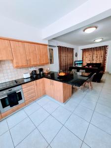 a kitchen with wooden cabinets and a living room at Villa Alkioni 31 in Paralimni