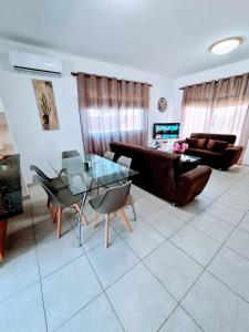 uma sala de estar com uma mesa de vidro e cadeiras em Villa Alkioni 31 em Paralimni