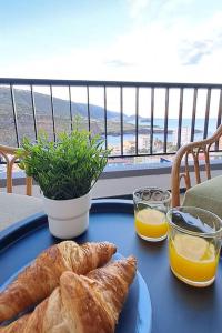 una mesa con un plato de pan y zumo de naranja en Playa San Marcos Apt.Mirador del Roque, en Icod de los Vinos