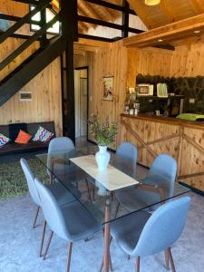 a dining room with a glass table and chairs at Les Chalets du Belvédère in Nevados de Chillan