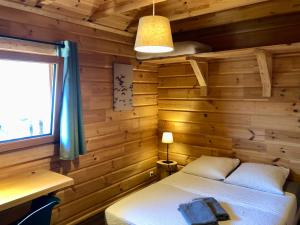 una camera da letto con letto in una camera in legno di Appart 50m2 4 à 5 pers dans Chalet de charme a Vimines