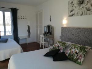 a bedroom with a bed and a table and a mirror at Le Kouloury in Meyronne