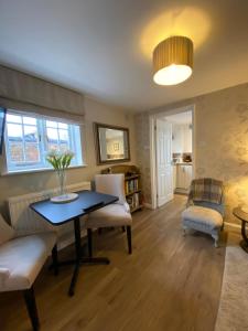 uma sala de estar com mesa e cadeiras em Charming 1 Bedroom Cottage Style Maisonette by HP Accommodation em Milton Keynes