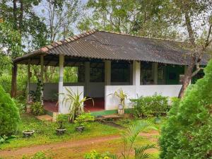 a house with a pavilion in a garden at Globetrotter Tourist Inn in Sigiriya