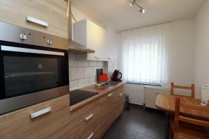 a kitchen with a large flat screen tv on the wall at Aparthotel Kompass A 102-103 in Essen