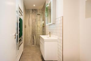 a white bathroom with a sink and a shower at Be London - The De Beauvoir Residences in London