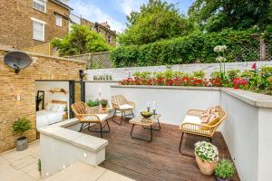 a patio with chairs and a table on a wooden deck at Be London - The De Beauvoir Residences in London