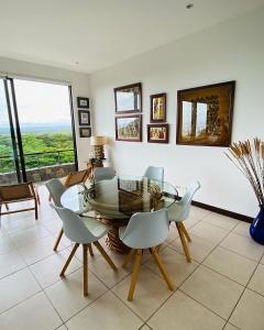 uma sala de jantar com uma mesa de vidro e cadeiras em Vista Lapas Nativa Resort em Jacó