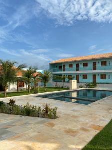 a swimming pool in front of a building at Pousada Maanain in Icapuí