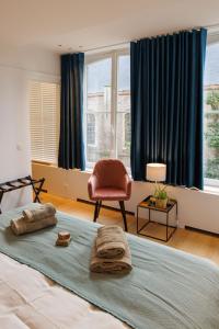 - une chambre avec un lit, une chaise et des fenêtres dans l'établissement APL8 St-Anna B&B, à Bruges