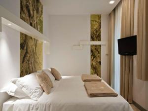 a bedroom with a white bed with towels on it at Eos Hotel in Lecce