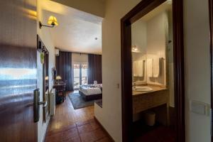 una camera d'albergo con bagno e una camera da letto di Hotel Vista Bela do Gerês a Outeiro