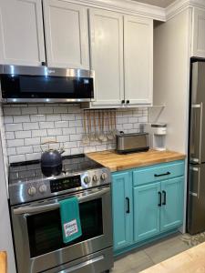 a kitchen with a stainless steel stove and blue cabinets at The Couples Nest Ocean Edge condo in Brewster